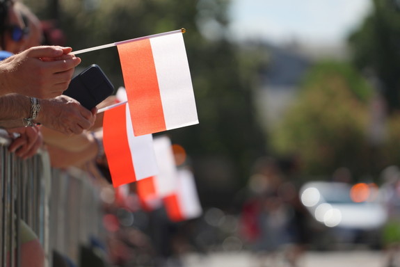 małe flagi trzymane przez świętujących ustawionych wzdłuż barierek na placu studzińskiego