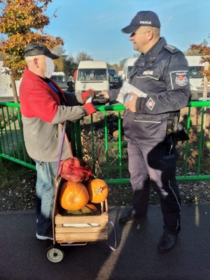 Dzielnicowy rozdaje ulotki