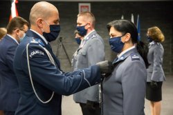 Komendant wręcz medal policjantce.