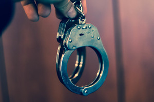 Osoba trzymająca kajdanki w ręku