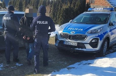 Policjanci prowadzą osobę zatrzymaną