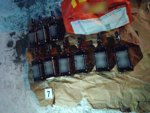 Szklane butelki leżące na ziemi.