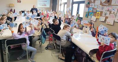 Policjanta przeprowadza prelekcję podczas ferii zimowych na terenie powiatu proszowickiego. Wspólne zdjęcia.