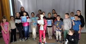 Policjanta przeprowadza prelekcję podczas ferii zimowych na terenie powiatu proszowickiego. Wspólne zdjęcia.