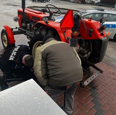 Policjant pomaga w naprawie koła