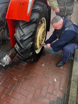 Policjant pomaga w naprawie koła