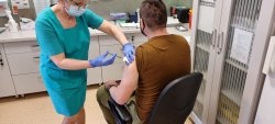 policjant podczas szczepienia przez pielęgniarkę