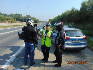 Kontrola drogowa motocyklistów, policjantka trzyma w ręku kartę medyczną