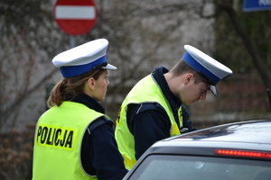 &quot;Policjantka i policjant ruchu drogowego kontrolują pojazd na drodze&quot;