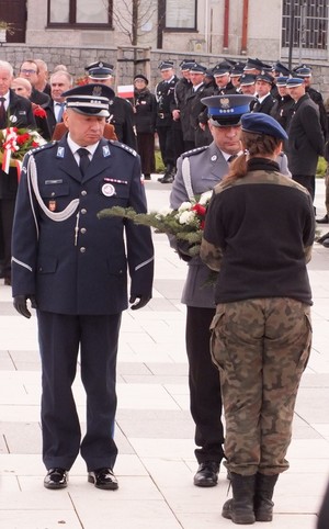 Złożenie kwiatów przez przedstawicieli Komendy Powiatowej Policji w Proszowicach i oddanie honoru: od lewej Komendant insp. Paweł Piętka oraz Naczelnik asp. szt. Damian Zapart