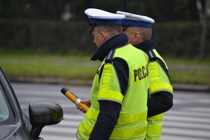 &quot;Policjanci ruchu drogowego podczas kontroli drogowej. Jeden z nich trzyma w ręku urządzenie do badania trzeźwości&quot;