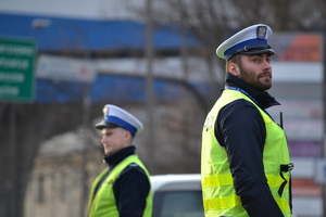 &quot;Dwóch policjantów ruchu drogowego nadzoruje ruch. Oboje stoją w pewnej od siebie&quot;