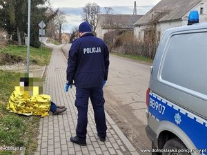 &quot;policjant toi obok osoby siedzącej na chodniku okrytej folią termiczną&quot;