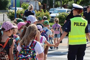 &quot;Policjantka prowadząca grupę dzieci w wieku szkolnym.&quot;