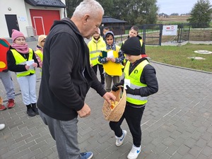 Akcja profilaktyczna &quot;Jabłko - Cytrynka&quot;. Uczniowie Szkoły Podstawowej w Mniszowie rozdawali jabłka i cytrynki dla kierujących stosujących się do przepisów ruchu drogowego oraz łamiących przepisy prawa.