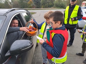 Akcja profilaktyczna &quot;Jabłko - Cytrynka&quot;. Uczniowie Szkoły Podstawowej w Mniszowie rozdawali jabłka i cytrynki dla kierujących stosujących się do przepisów ruchu drogowego oraz łamiących przepisy prawa.